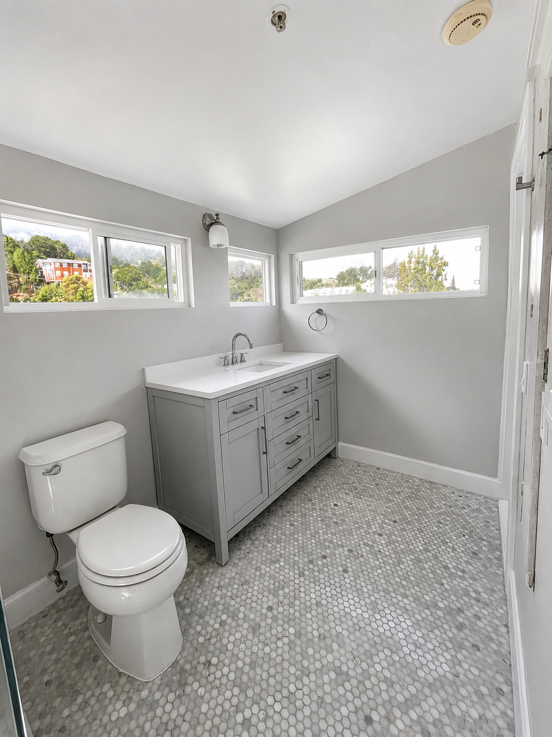 Finished bathroom renovation with vanity and pebble floor