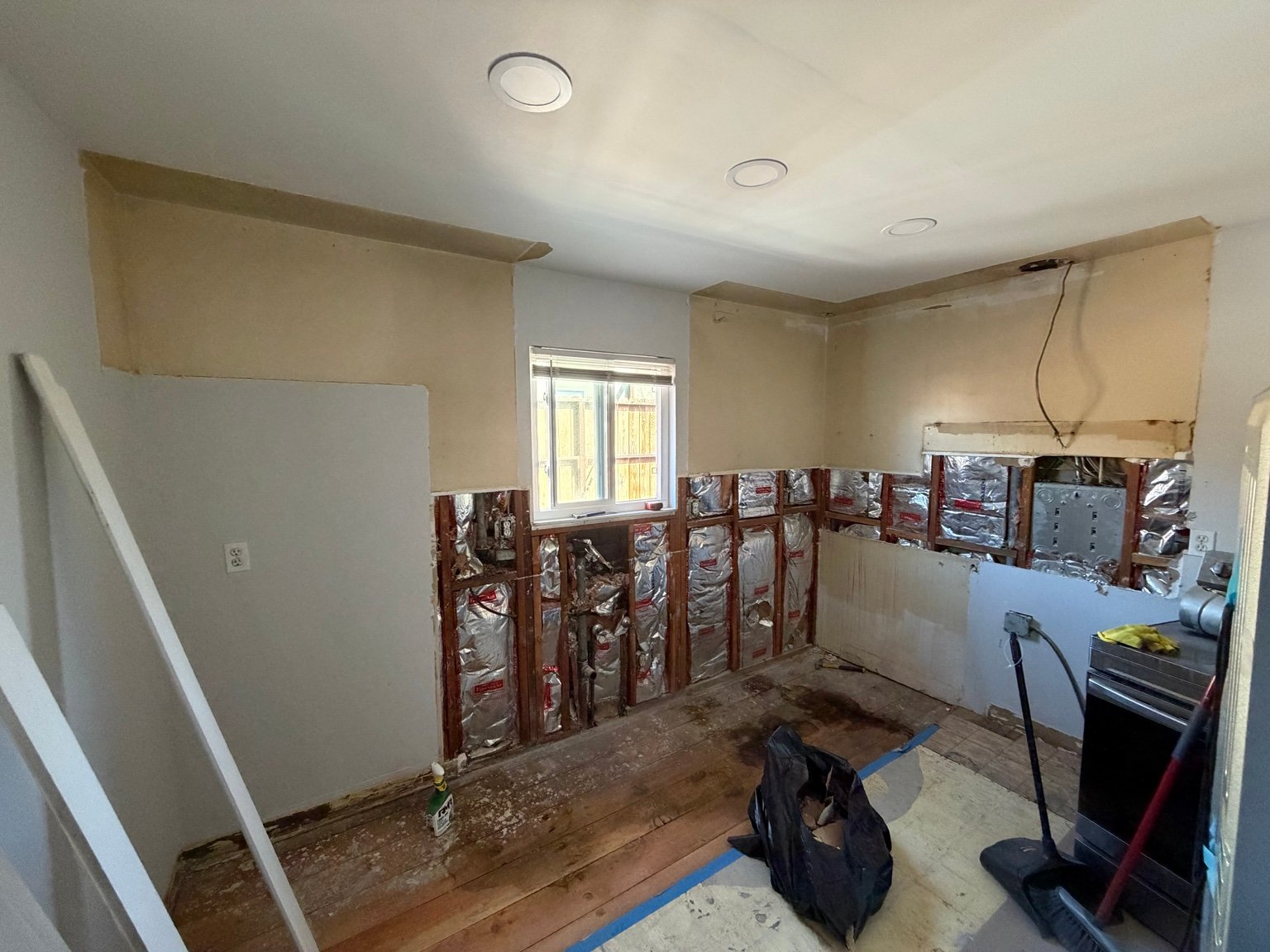Kitchen renovation during demolition with wall cavities exposed